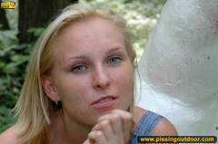 Outdoor pissing on a white statue in a forest