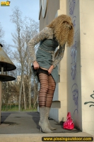 MILF blonde pissing outdoot on the painted pedestal