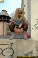 MILF blonde pissing outdoot on the painted pedestal