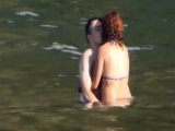 Horny couple having some fun in the water at the beach